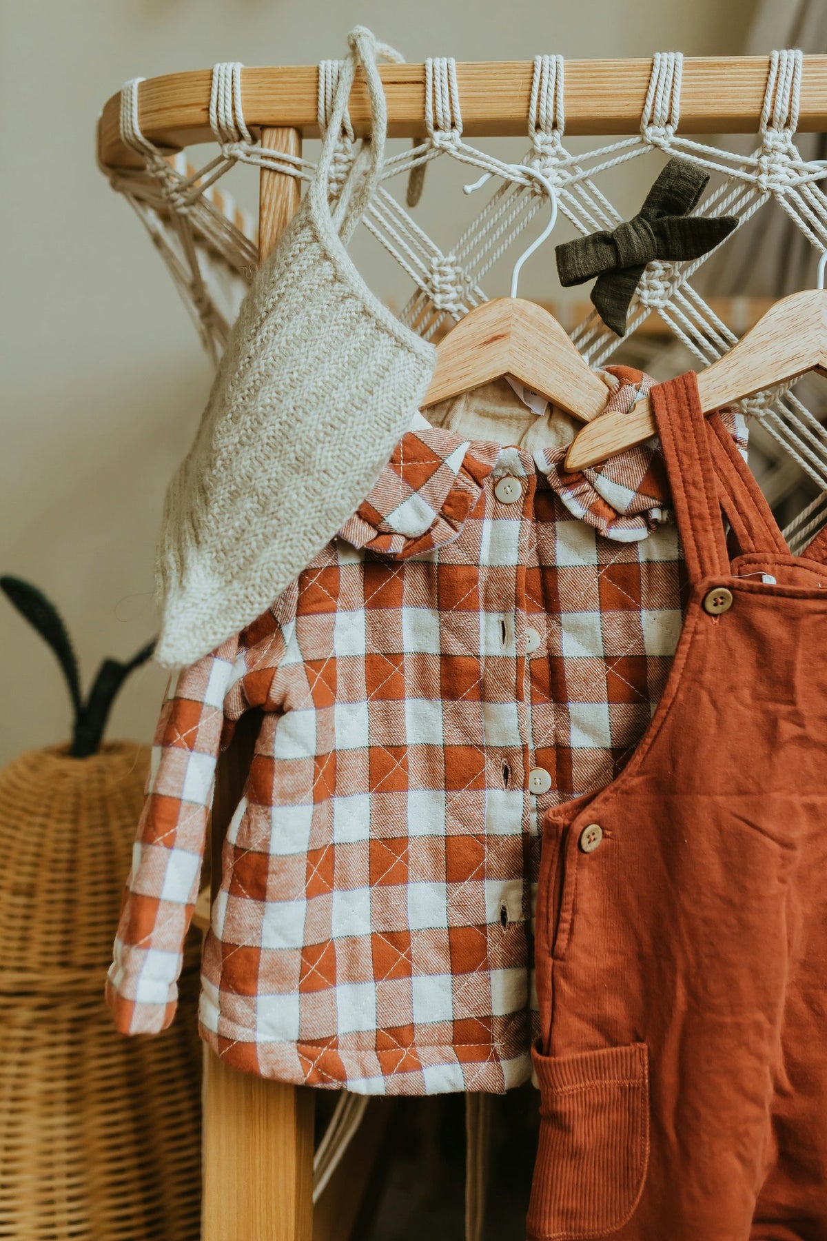 Gingham shirt and rust dungarees on a small wooden clothes rail